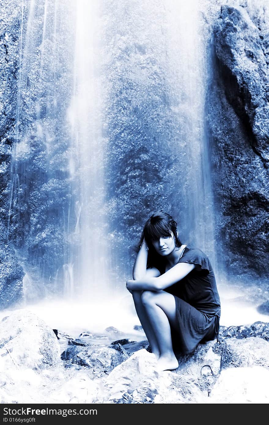 Young woman posing under long exposed waterfall. Young woman posing under long exposed waterfall