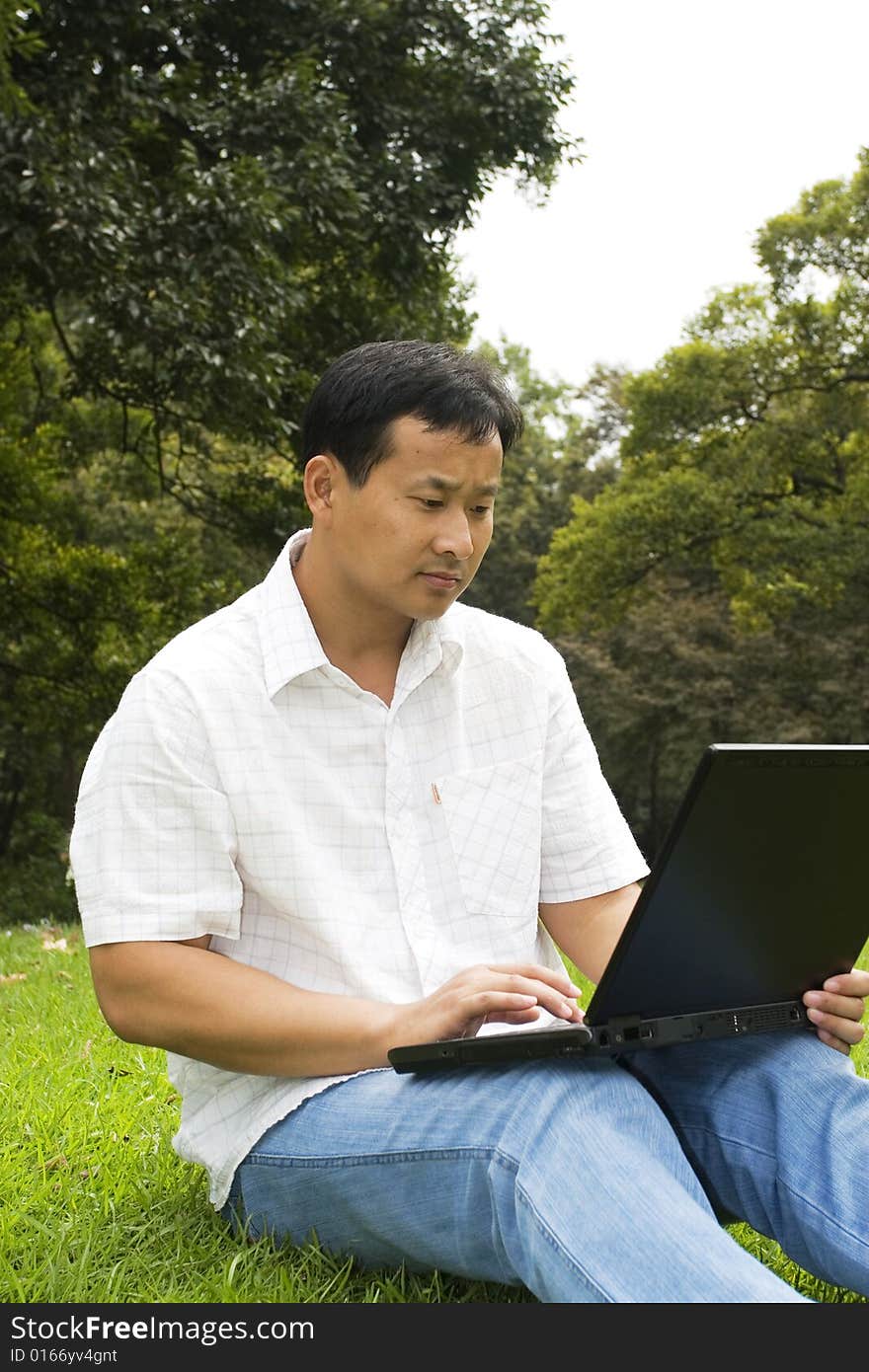 A young man using a laptop outdoors