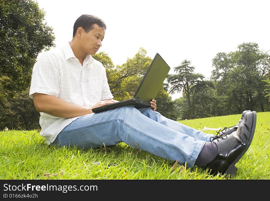 A young man using a laptop outdoors