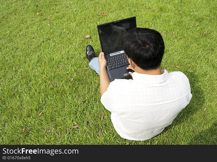 A young man using a laptop outdoors