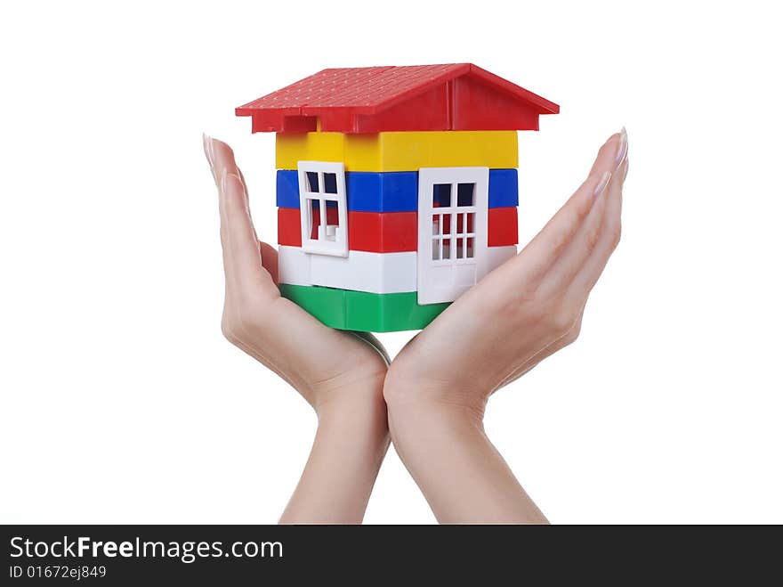 Toy colour plastic house with red roof in palms of young woman. Toy colour plastic house with red roof in palms of young woman