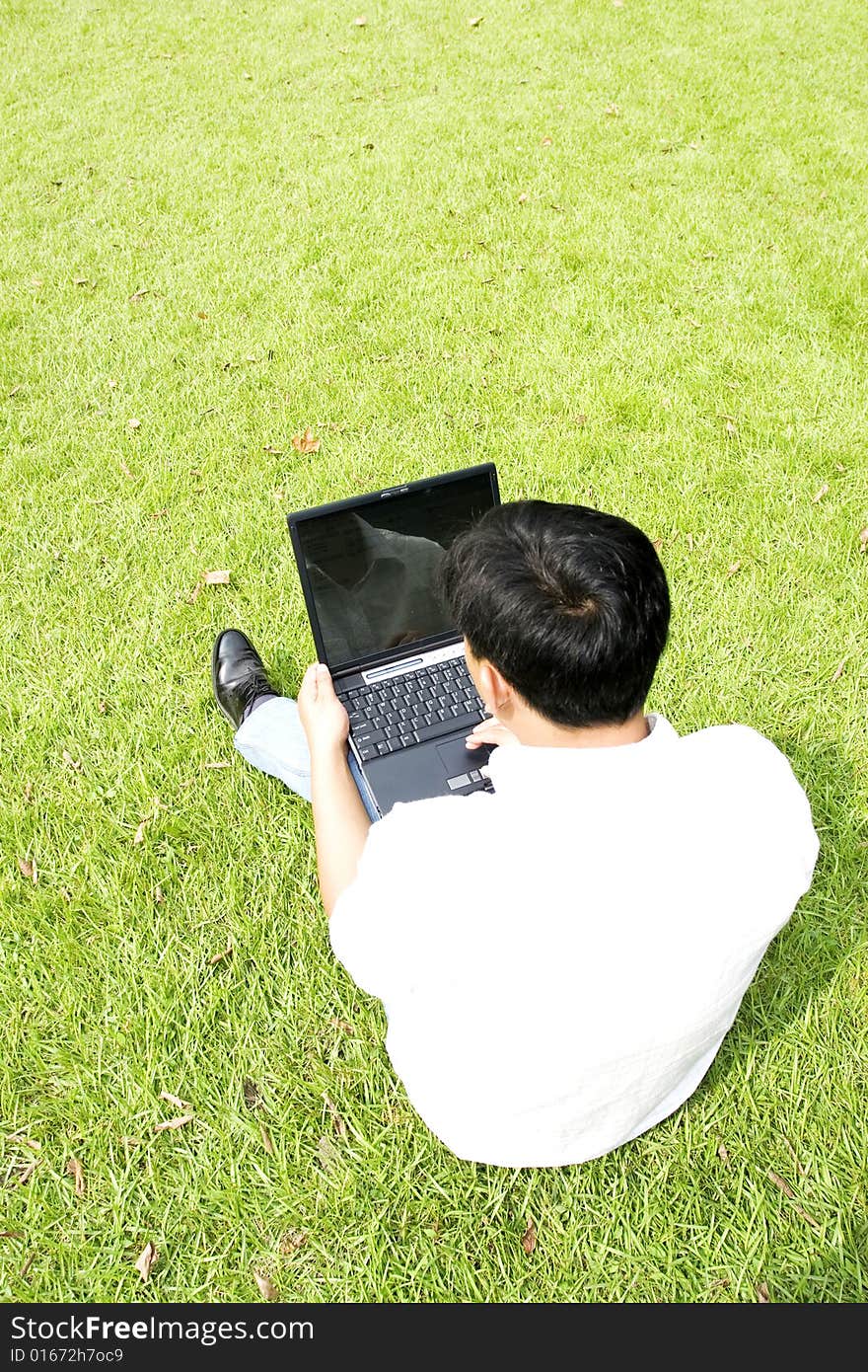 A young man using a laptop outdoors