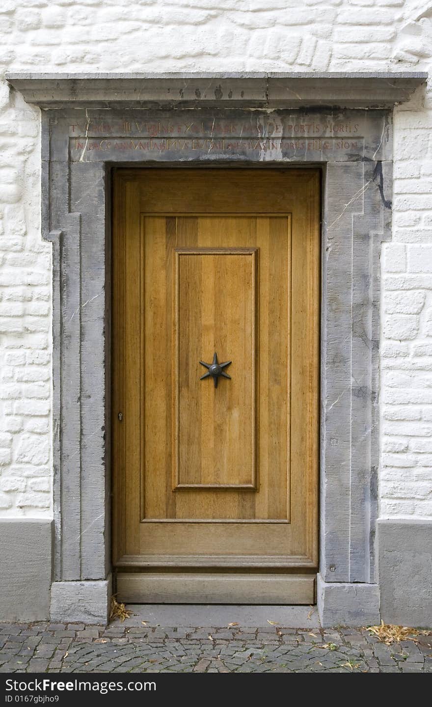 Old woodden Door with a marble marble.The marble frame has a inscription on the Latin. Old woodden Door with a marble marble.The marble frame has a inscription on the Latin.