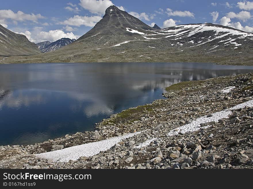 Mountains With Lake Reflection In Norway