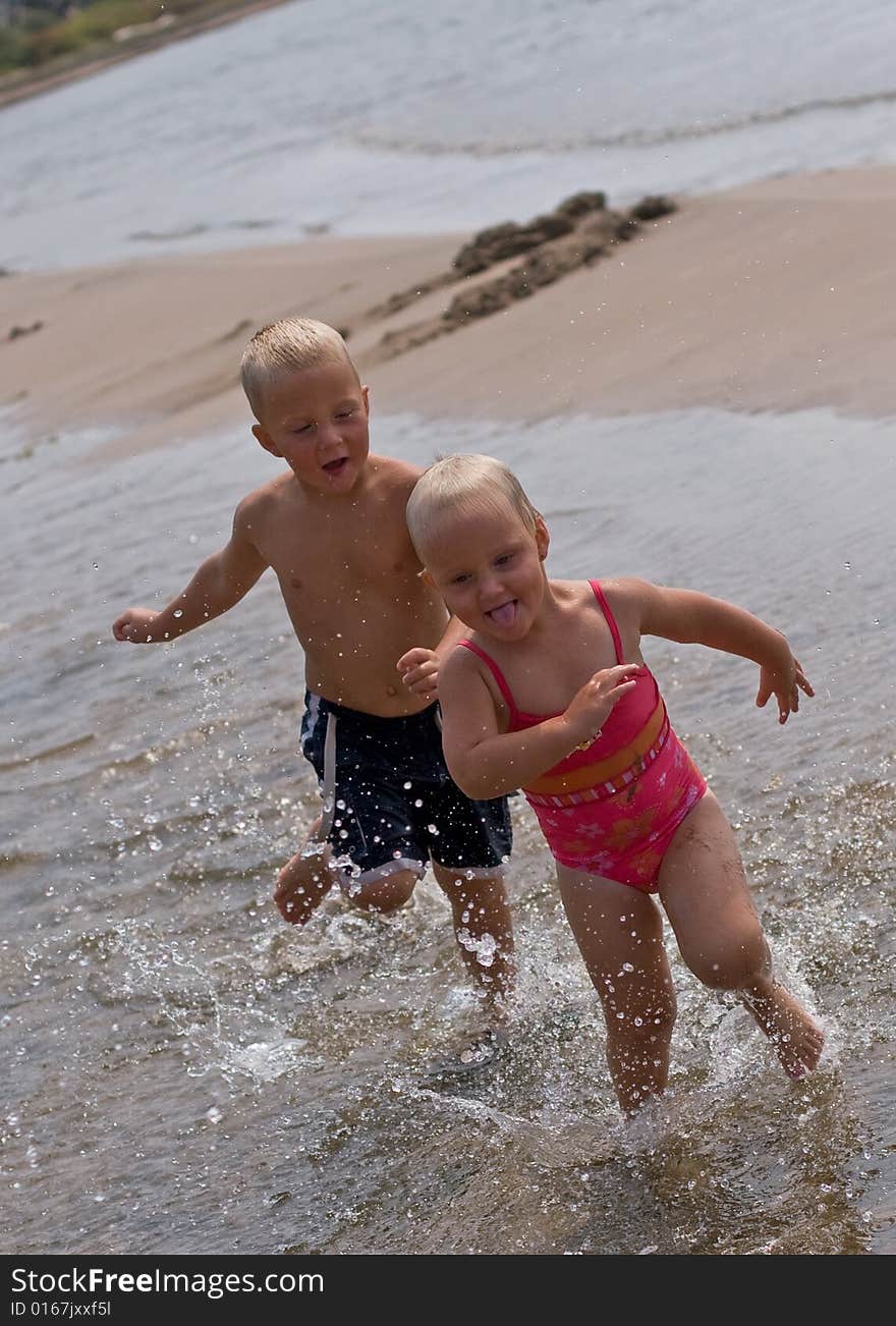 Boy chasing girl at the beach. Boy chasing girl at the beach