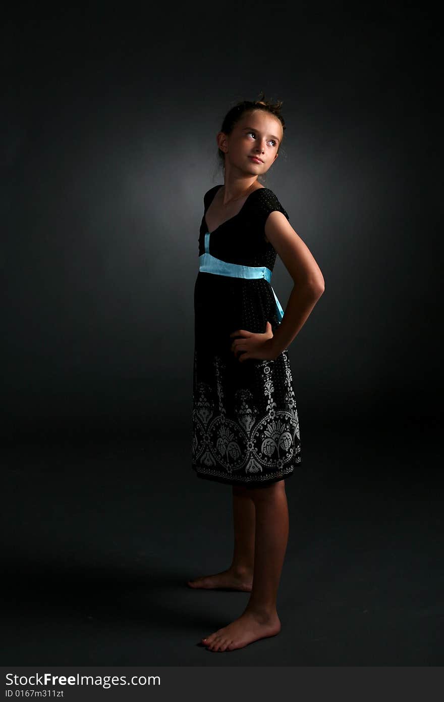 Studio portrait of aloof, confident looking young pretty girl in black dress. Studio portrait of aloof, confident looking young pretty girl in black dress