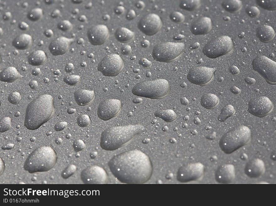 Rain drops on metallic surface closeup