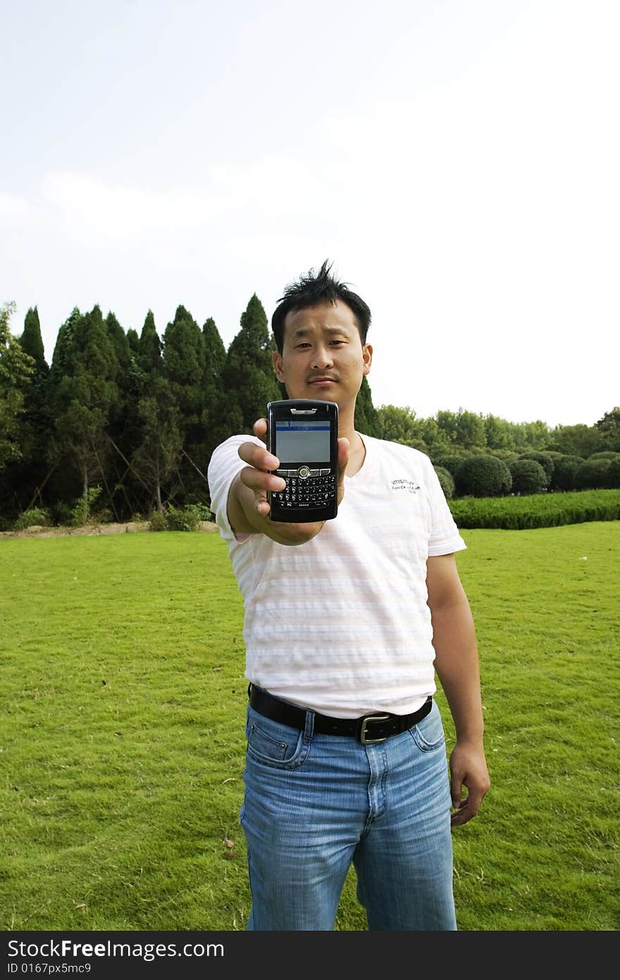 The man using cell phone outdoors.