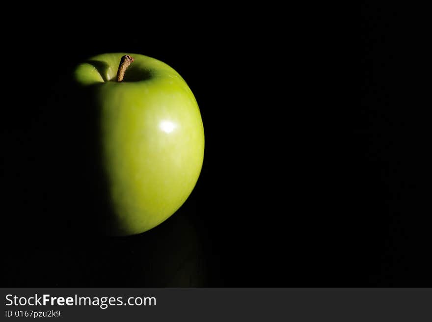 Fresh green apple on a black backdrop