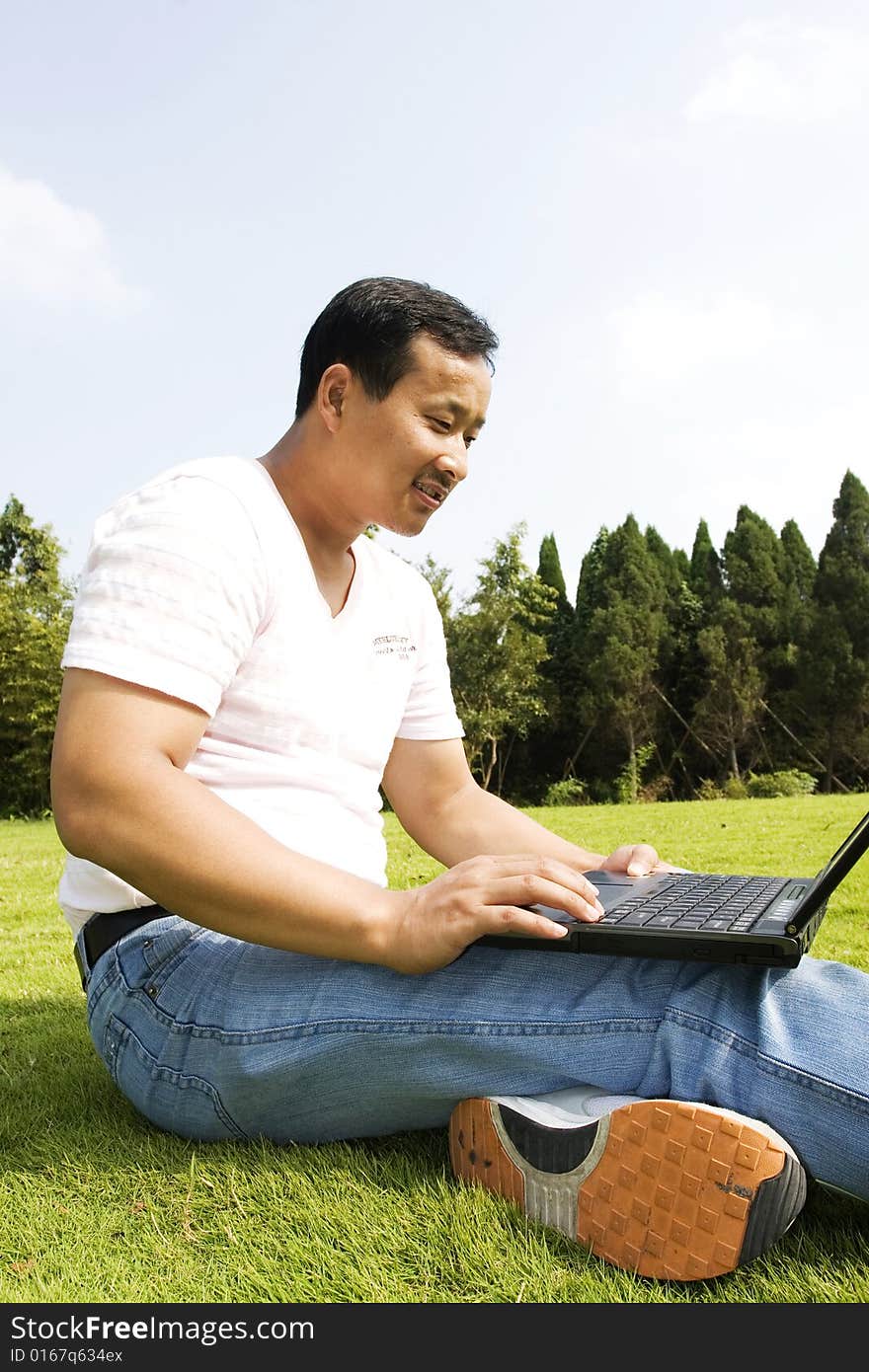 A young man using a laptop outdoors