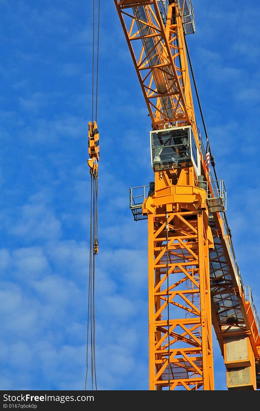 Yellow construction crane aginst blue sky