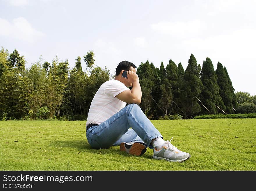 The man using cell phone outdoors.