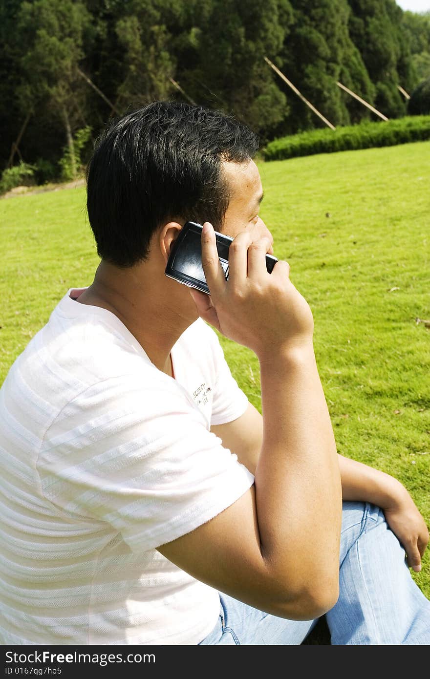 The man using cell phone outdoors.