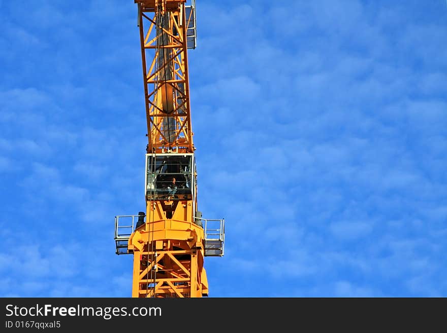 Yellow construction crane aginst blue sky