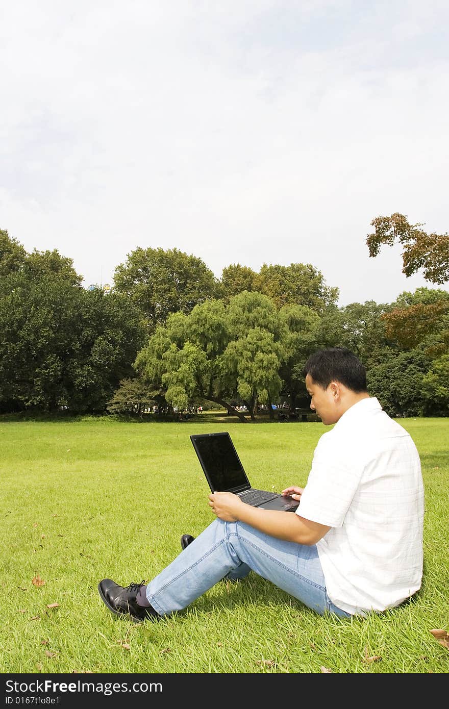 A young man using a laptop outdoors