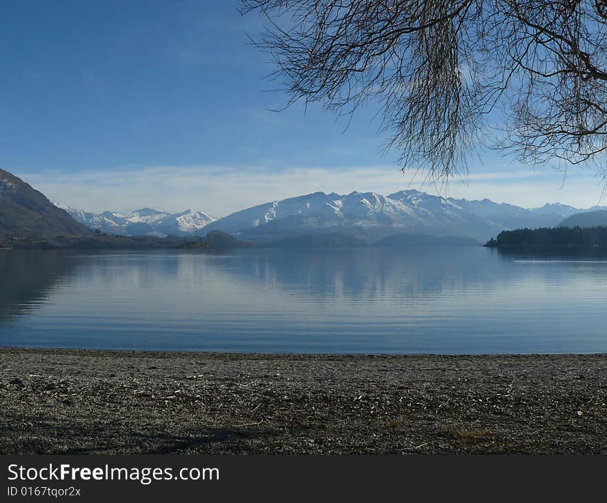 A calm lake surrounded by snowy mountains. A calm lake surrounded by snowy mountains.