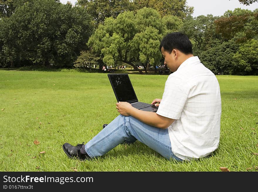 A young man using a laptop outdoors