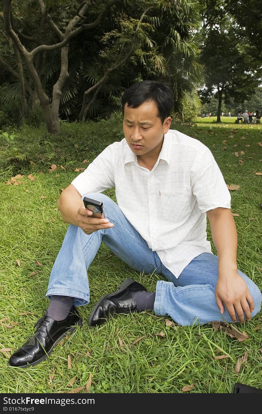 The man using cell phone outdoors.