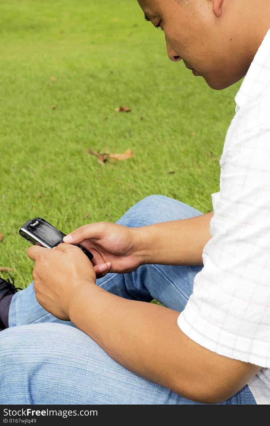 The man using cell phone outdoors.