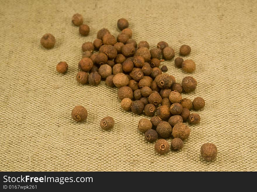 Whole dried allspice fruits on burlap