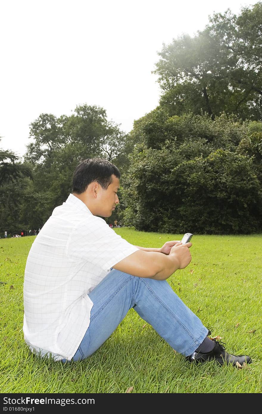 The man using cell phone outdoors.