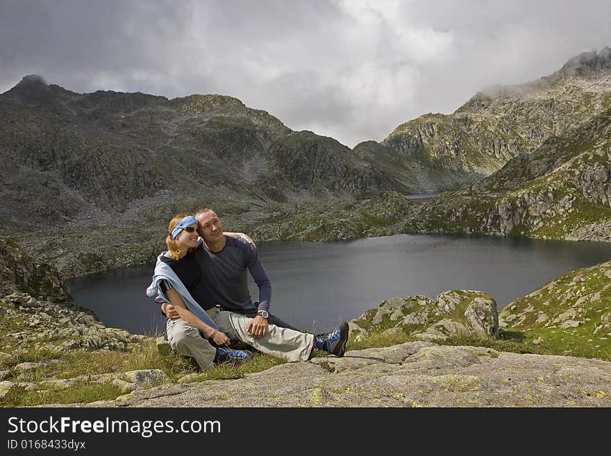 A couple relaxing at lake in Italian mountains. A couple relaxing at lake in Italian mountains