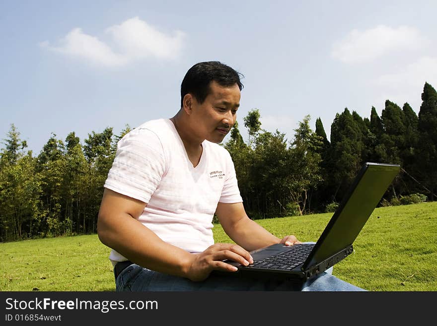 A young man using a laptop outdoors