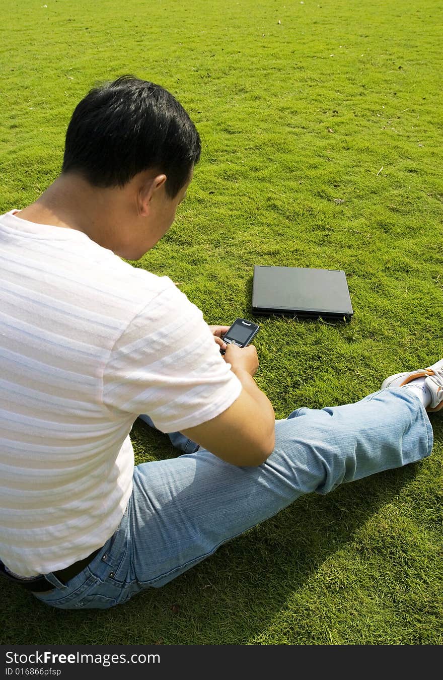 The man using cell phone outdoors.