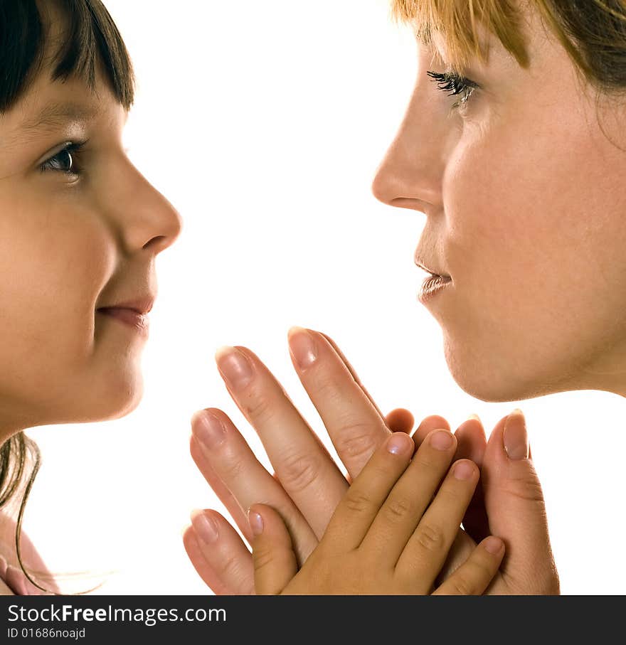 Mother and daughter looking each other in eyes on white