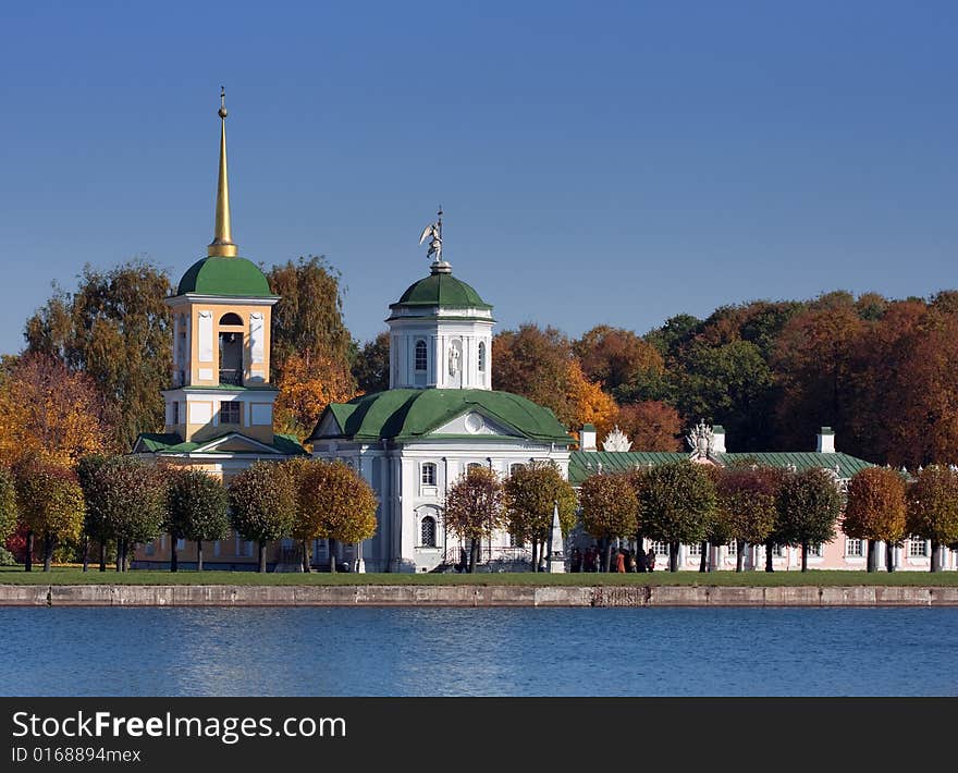 Old steeple on the shore of lake on blue sky background. Old steeple on the shore of lake on blue sky background