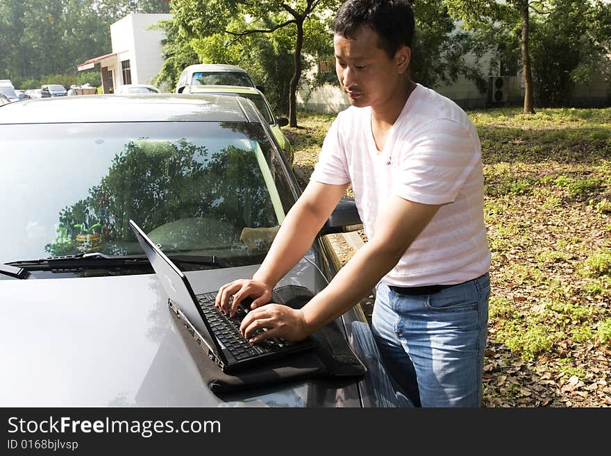 The man working outdoors with a laptop.