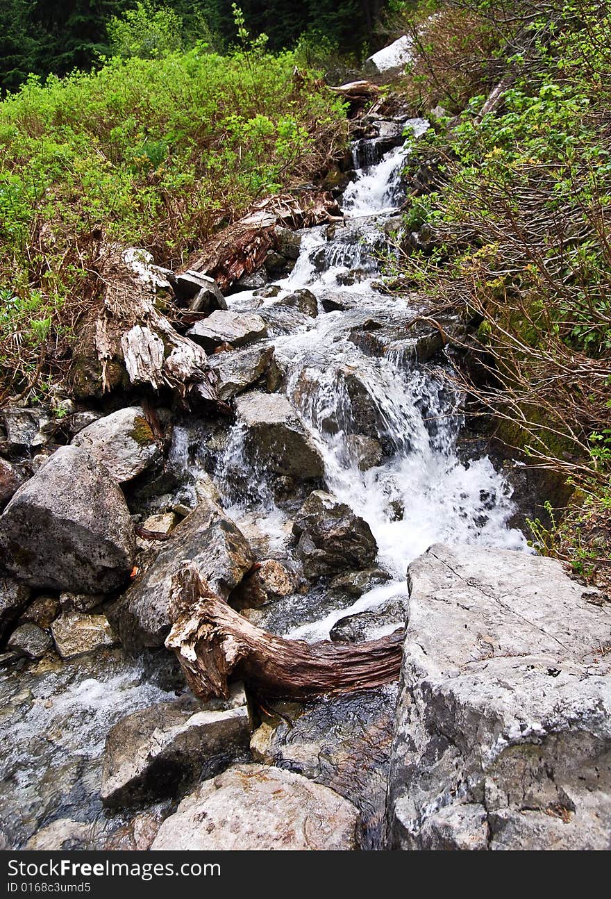 Water flowing down through a river filled with rocks. Water flowing down through a river filled with rocks.