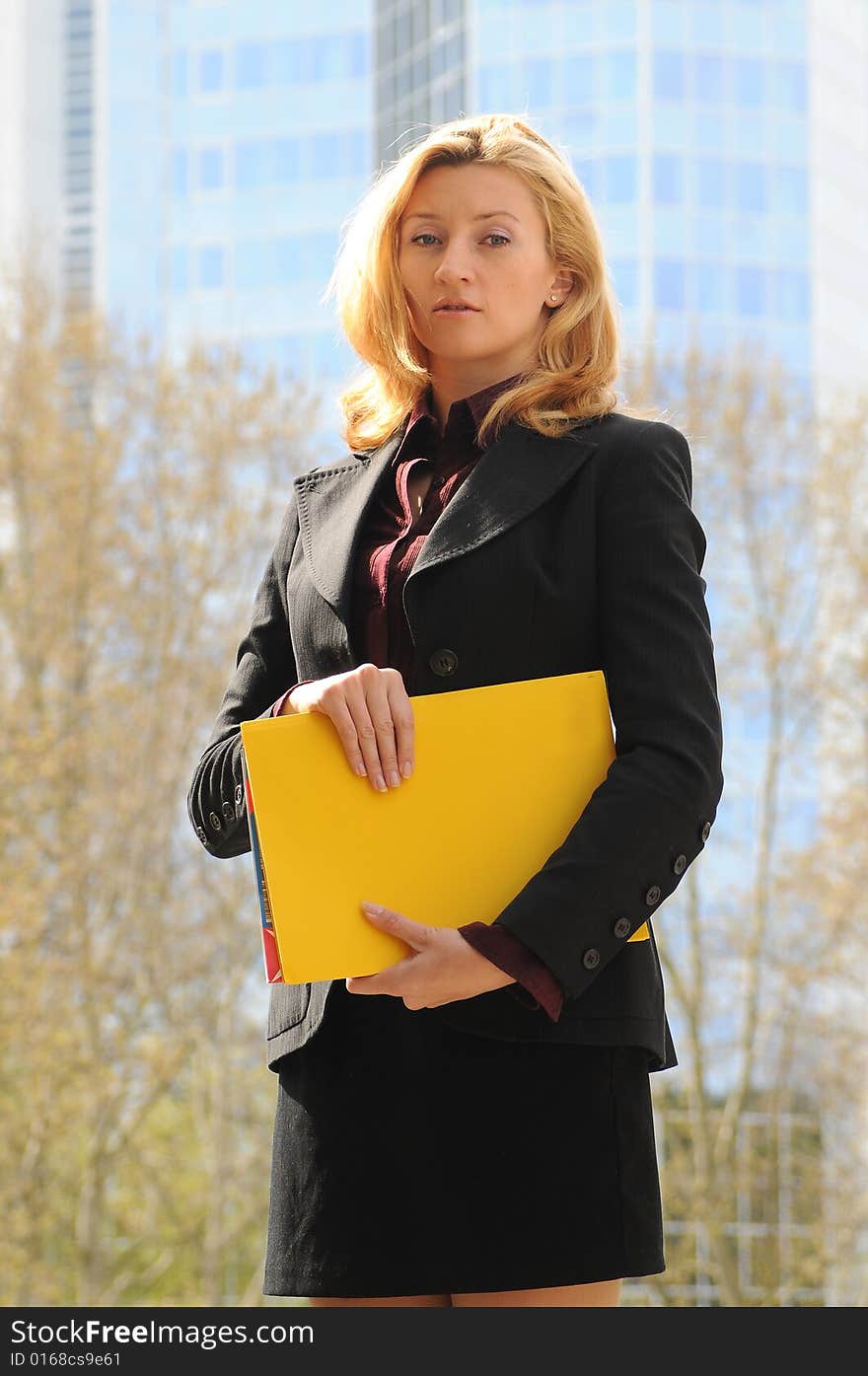 Young business woman holding yellow file. Financial district,Frankfurt,Germany.