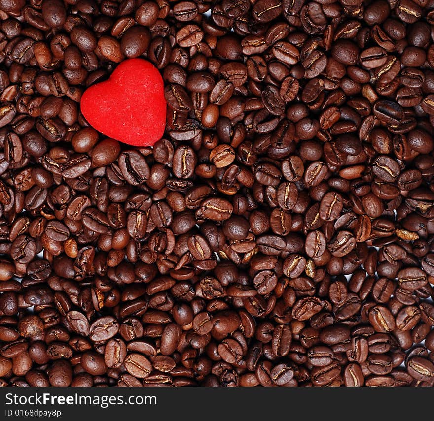 Red heart in the heap of brown coffee seends. Red heart in the heap of brown coffee seends