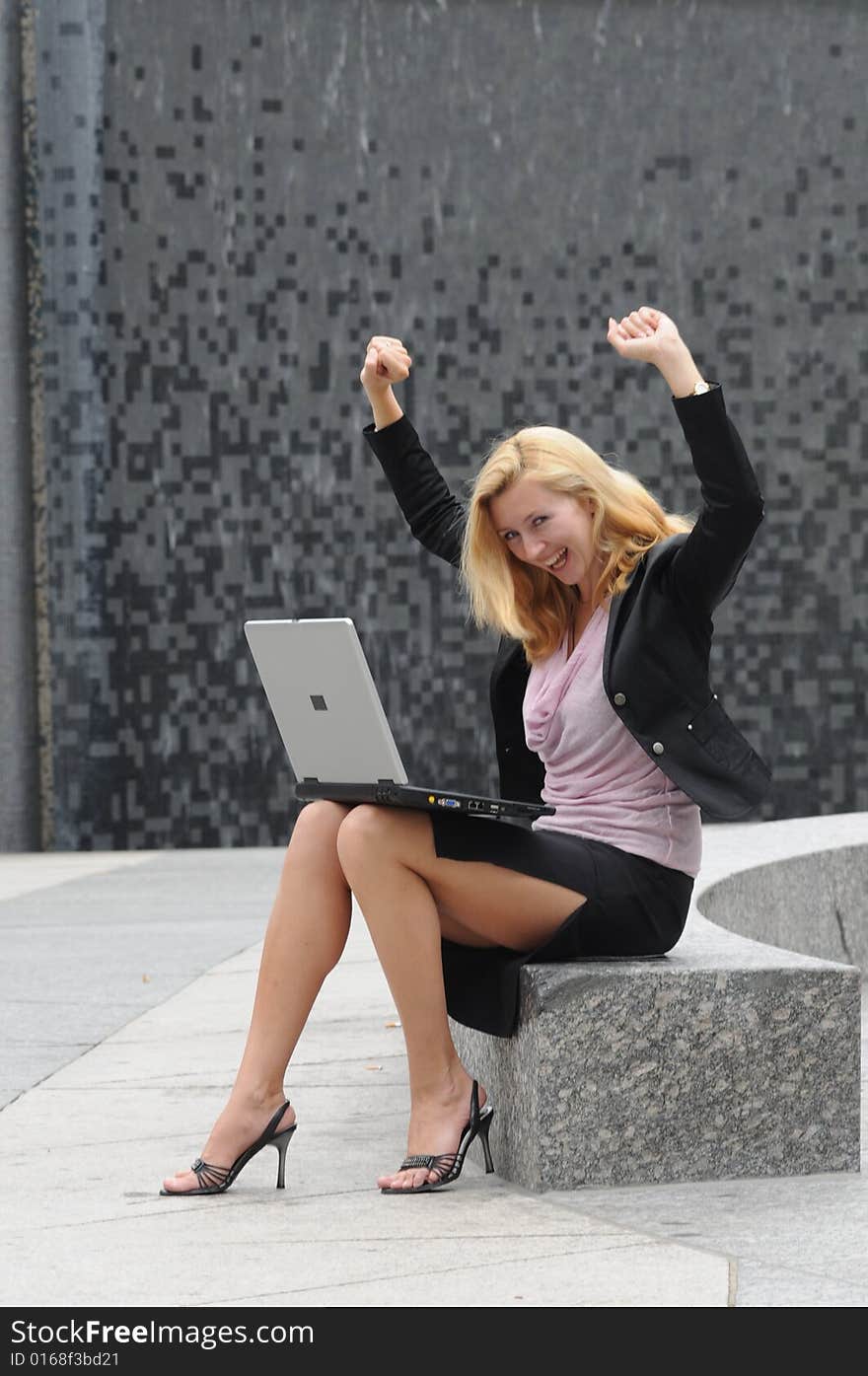 Young business woman gesturing due to successful work on her laptop.