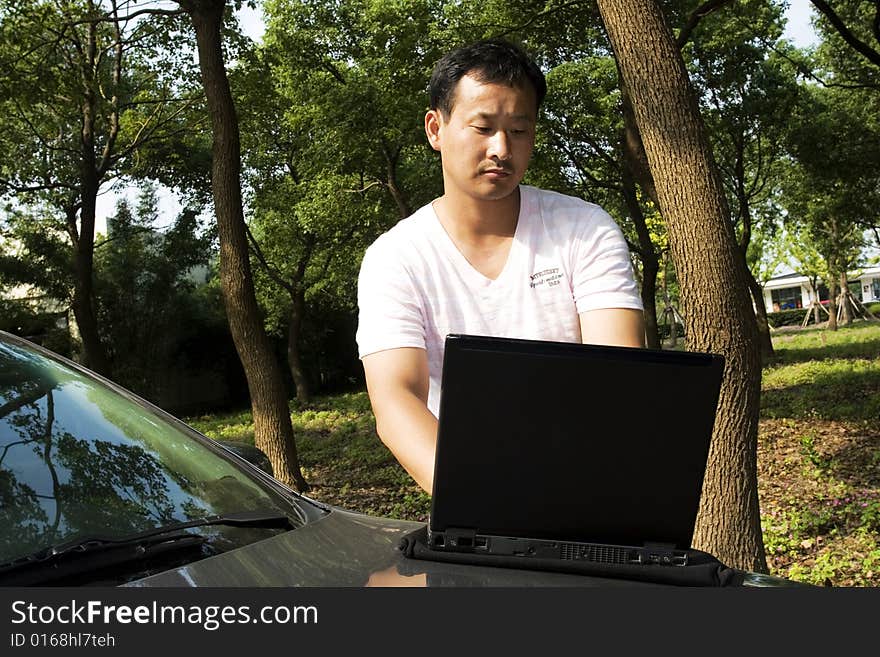 The man working outdoors with a laptop.