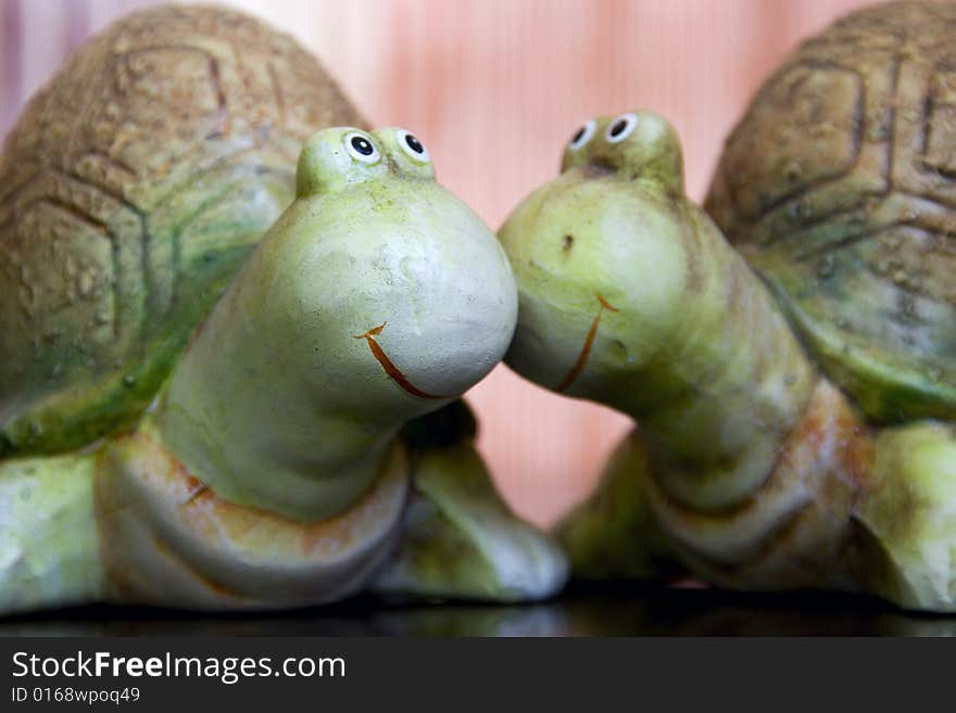 One turtle lovingly kisses the cheek of another turtle. One turtle lovingly kisses the cheek of another turtle.