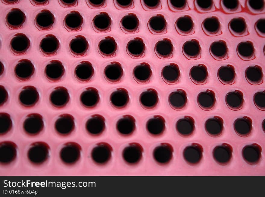 Close-up, abstract, round, holes, vent, venting, background, diagonal, metal, texture, red, ruby. Close-up, abstract, round, holes, vent, venting, background, diagonal, metal, texture, red, ruby