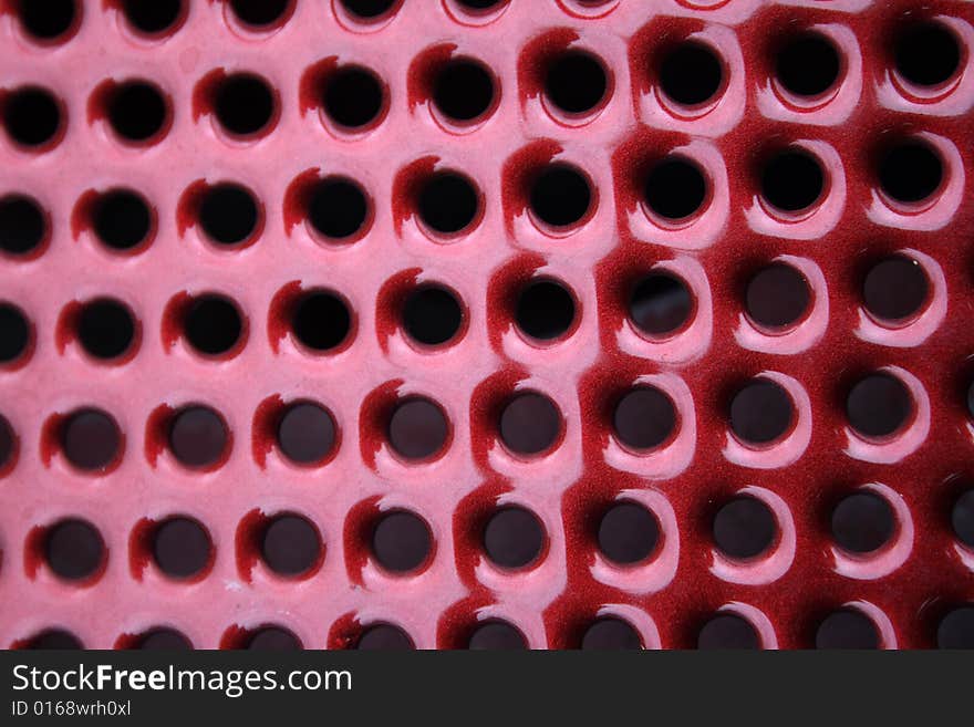 Close-up, abstract, round, holes, vent, venting, background, diagonal, metal, texture, red, ruby. Close-up, abstract, round, holes, vent, venting, background, diagonal, metal, texture, red, ruby