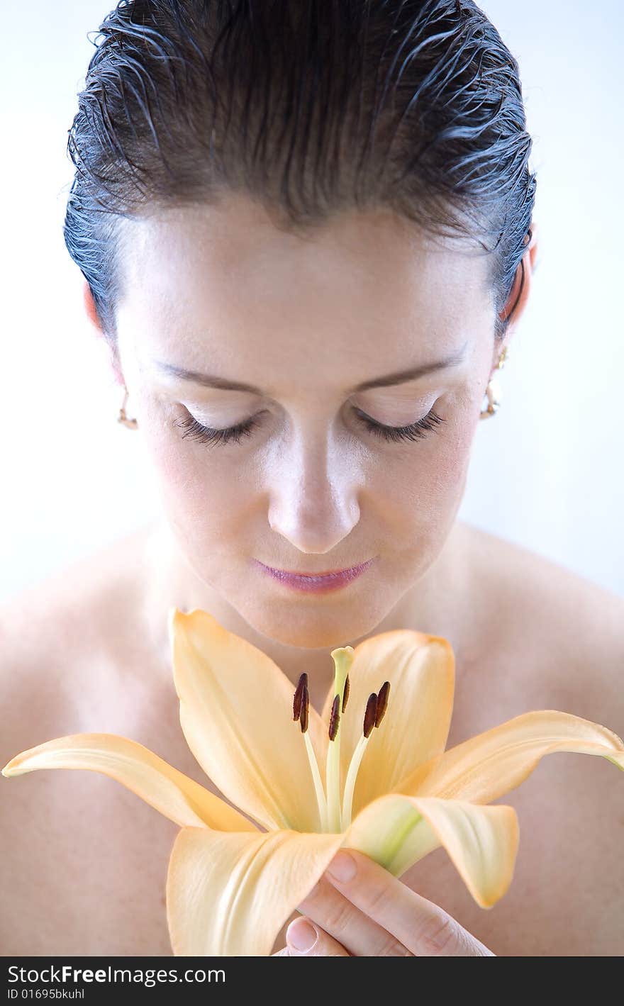 High key portrait of nice brunette with big lily flower. High key portrait of nice brunette with big lily flower