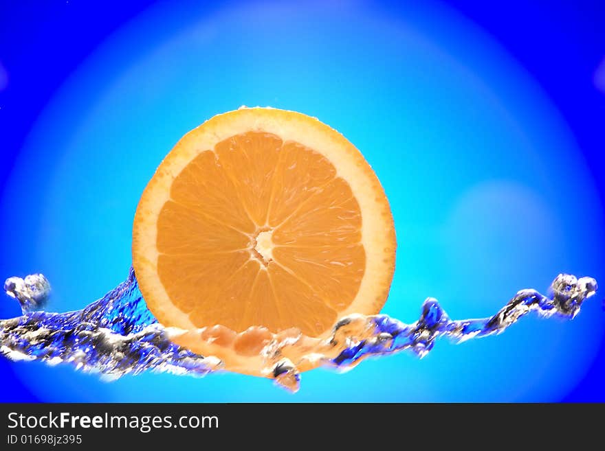 Close up view of sliced orange piece getting splashed with water. Close up view of sliced orange piece getting splashed with water