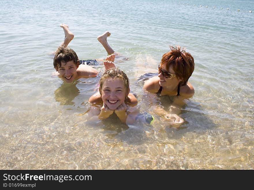 Children with mother lying on the beach and looking happy. Children with mother lying on the beach and looking happy.