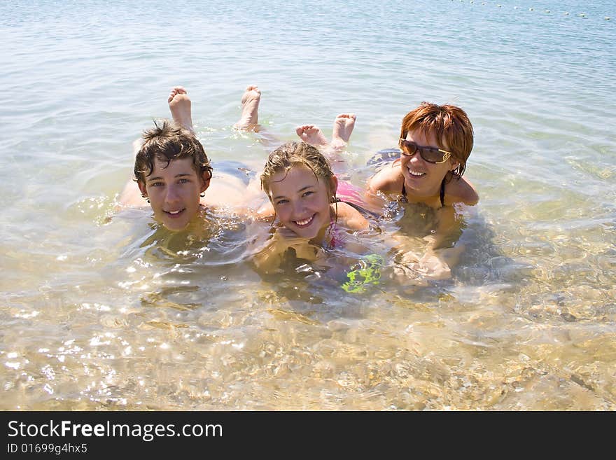 Children with mother lying on the beach and looking happy. Children with mother lying on the beach and looking happy.