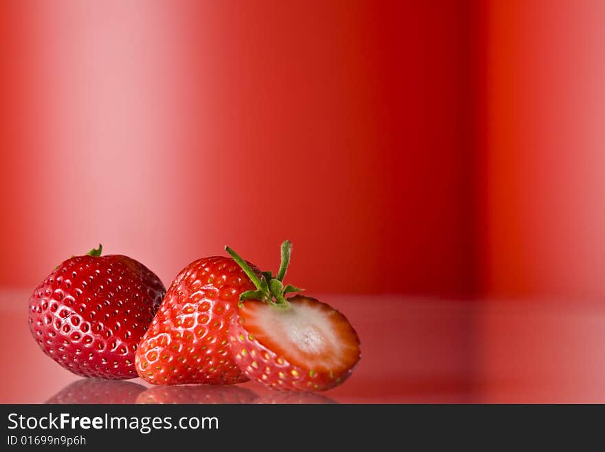 Close up view of nice fresh red berry on red back. Close up view of nice fresh red berry on red back