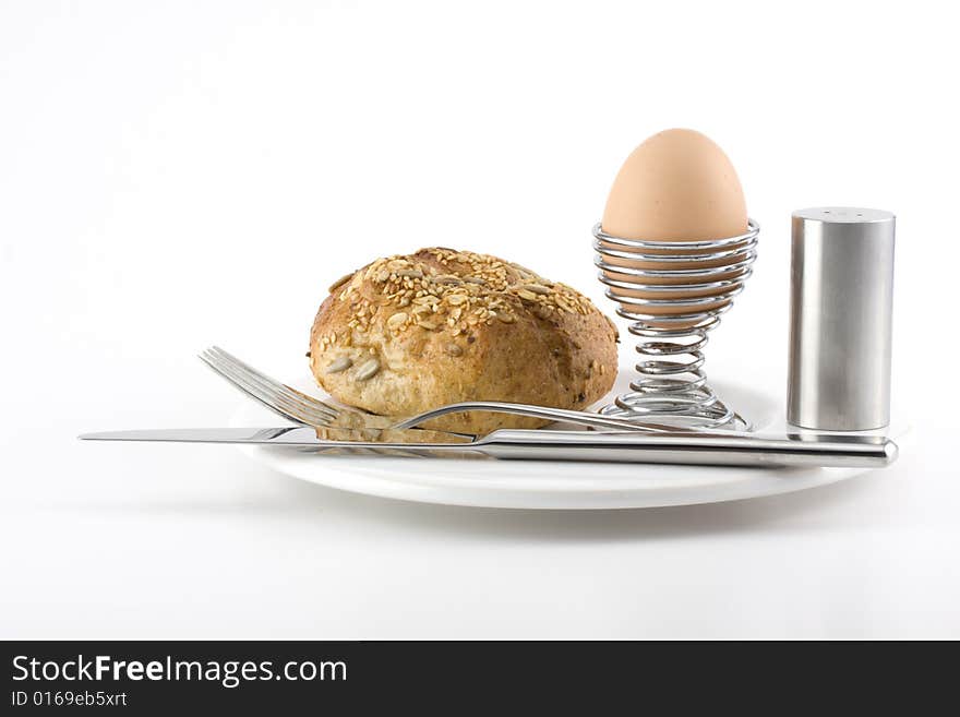 Bun, egg, cutlery and a white plate. Bun, egg, cutlery and a white plate