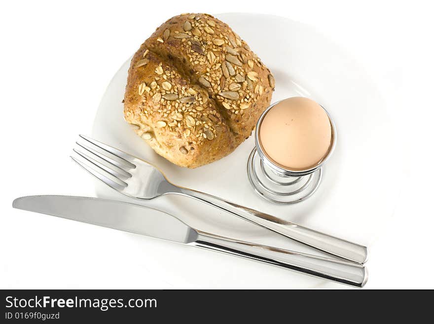 Bun, egg, cutlery and a white plate. Bun, egg, cutlery and a white plate