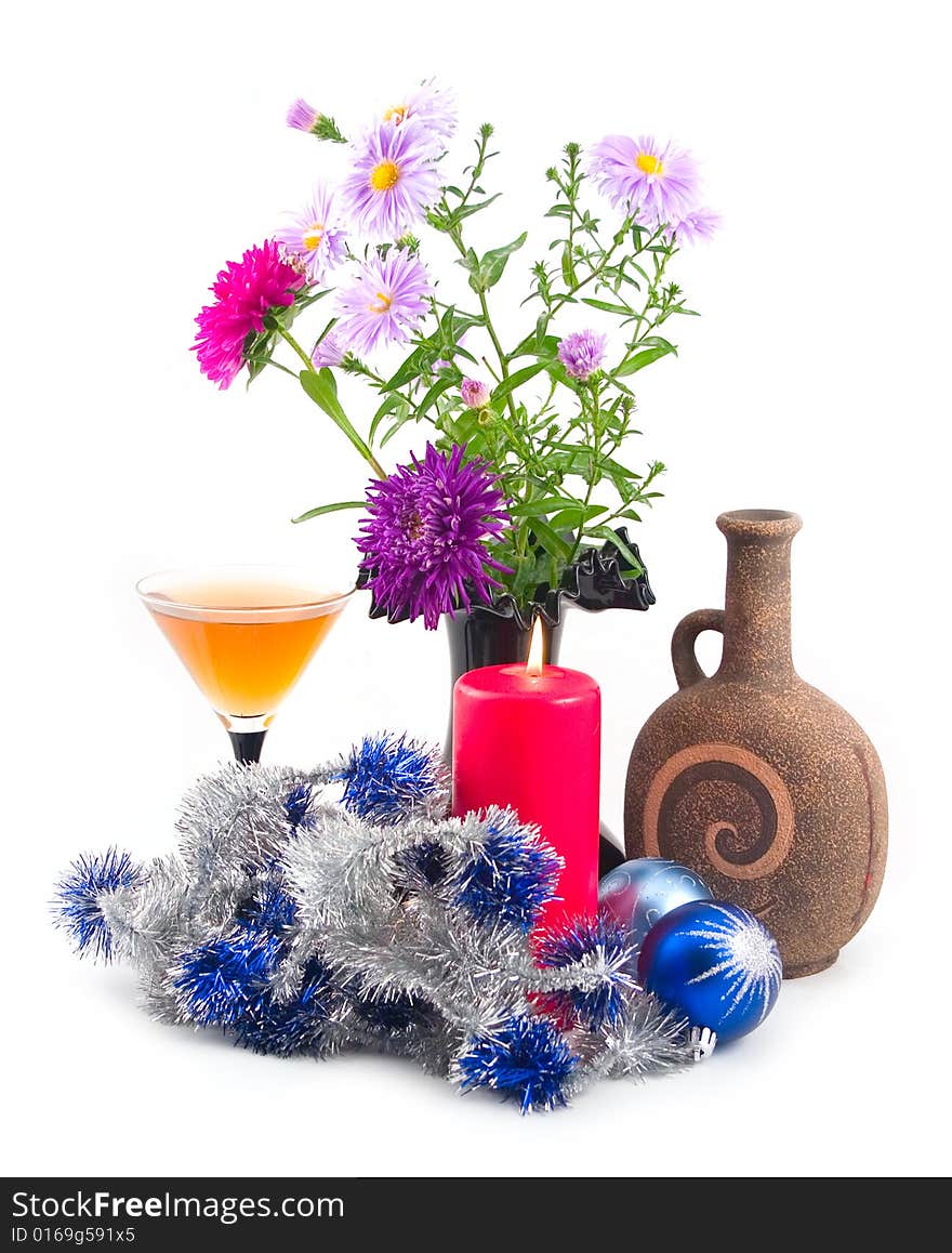 Red burning candle at black vase with colors and ceramic bottle with wine on white background