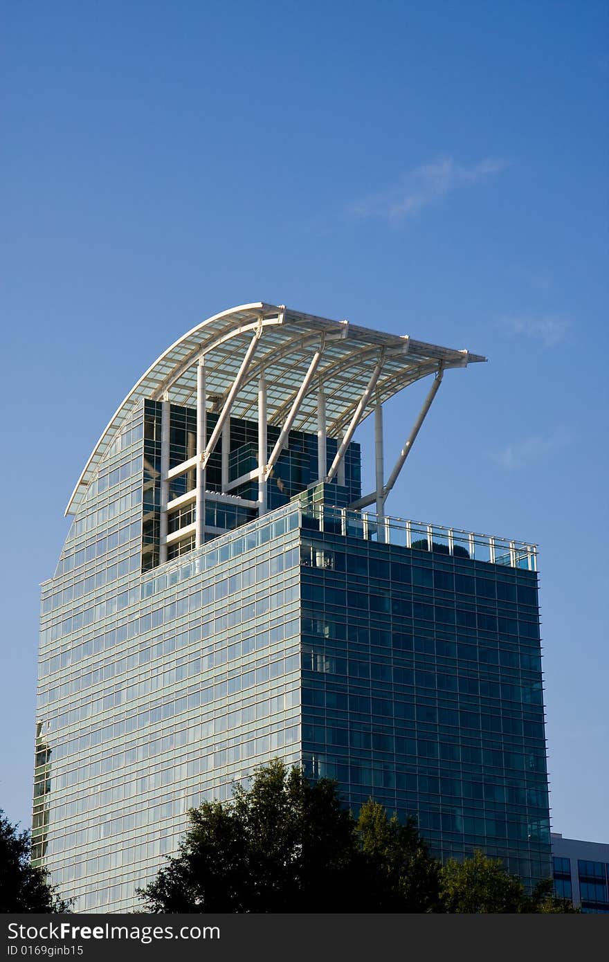 A blue glass office building with a curved roof. A blue glass office building with a curved roof