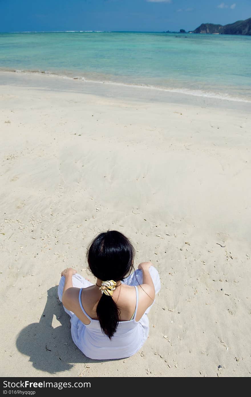 Young woman meditating on the beach