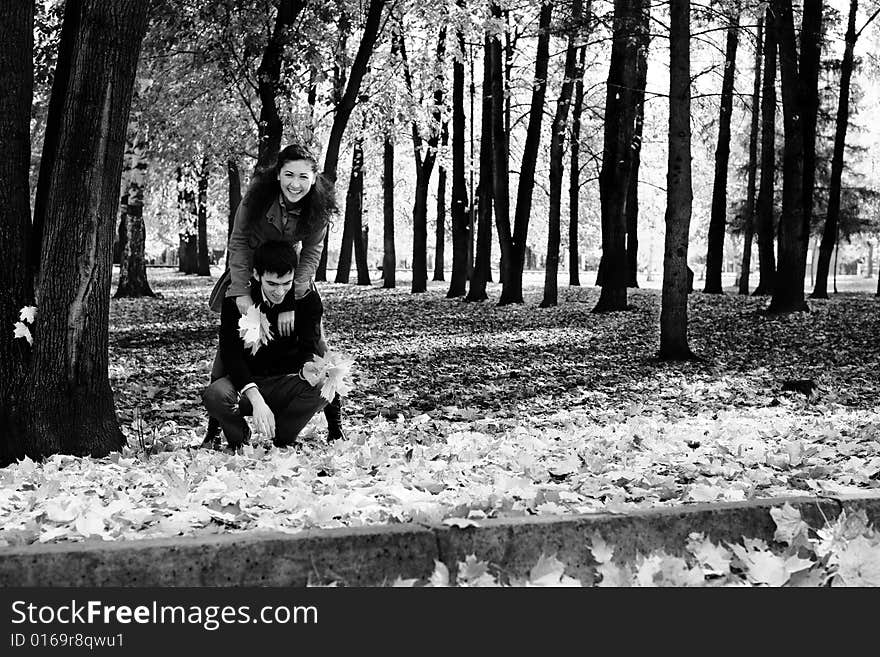 Young beautiful couple have fun In autumn foliage. Young beautiful couple have fun In autumn foliage